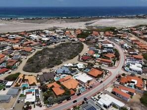 Un quartier résidentiel situé sur la côte, avec des maisons, une plage et une vue dégagée sur l’océan.
