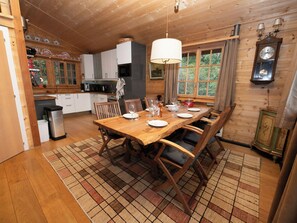 A wooden interior with a dining table set for four, surrounded by chairs. - Prima 1084 by Interhome (Nendaz)