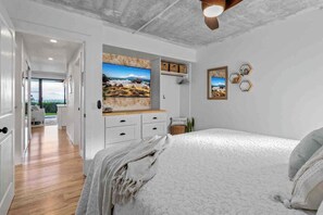 A bedroom with a bed, a desk, and a view of the outdoors. - Ma'alaea Ocean Front • Whales, Pool & Hot Tub (Wailuku)