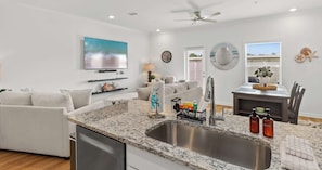 A modern kitchen with granite countertops, a stainless steel sink, and a dishwasher. - Easy Days at Lost Bay - 3BDR (Orange Beach)