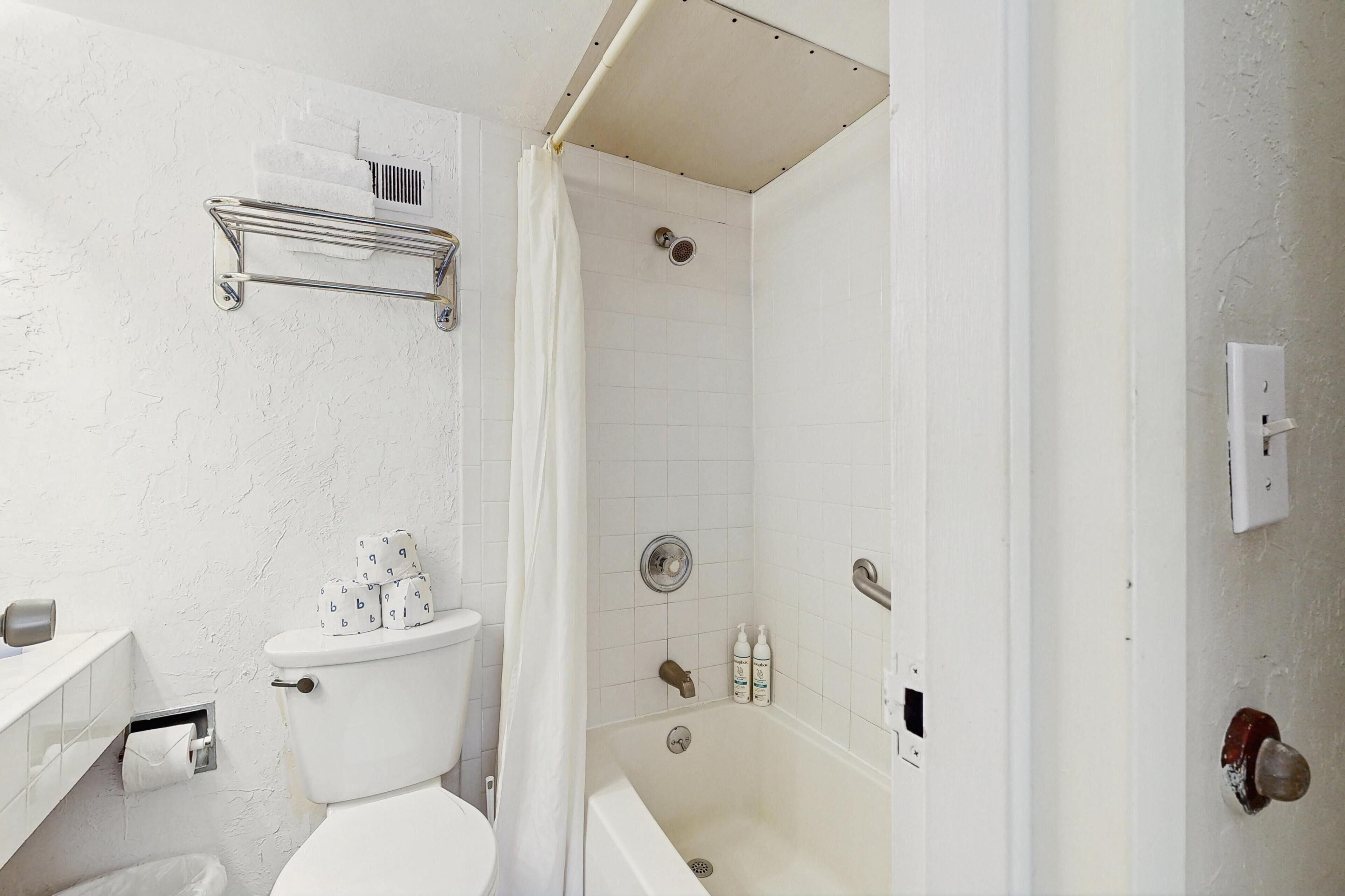 A bathroom with a toilet, a shower, and a bathtub.