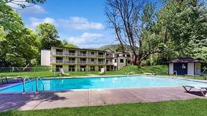 Ein Hotel mit Pool, Außenbereich und einem Gebäude mit mehreren Balkonen.