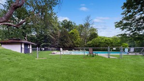 A fenced backyard with a swimming pool, a small shed, and a grassy lawn. - Four Season Condo: seasonal pool, ski, hike & golf (Warren)