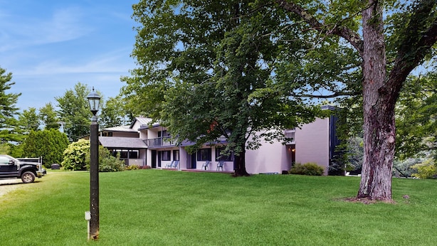 A residential area with a large tree, a street lamp, and a building with a balcony. - Four Season Condo: seasonal pool, ski, hike & golf (Warren)