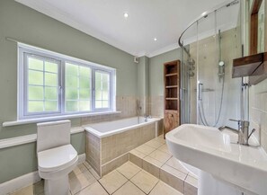 Ein Badezimmer mit Toilette, Badewanne, Dusche und Waschbecken.