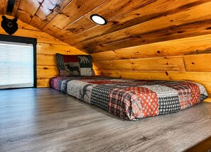 A cozy cabin room with a wooden ceiling, a bed with a patterned quilt, and a bear head decoration on the wall. - Escape to Black Bear Cabin near Red River Gorge, your private woodland retreat. (campton)