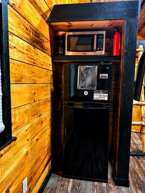 A compact kitchenette with a microwave and a refrigerator, enclosed in a wooden cabinet. - Escape to Black Bear Cabin near Red River Gorge, your private woodland retreat. (campton)