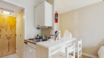 Una kitchenette compacta con estufa, lavabo y armarios.