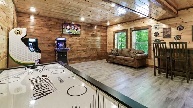 A wooden interior with a pool table, a sofa, and a bar area. - Endless MTN Escape: Spacious, Hot Tub, MORE GAMES! (Sevierville)