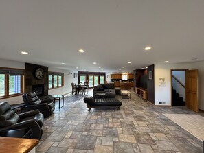 Ein geräumiges Wohnzimmer mit Kamin, Essbereich und Küche.