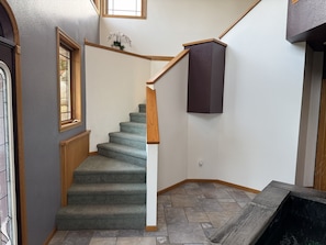 Eine Treppe mit Teppichstufen, Holzhandläufen und einer dunkel gefärbten Wand.