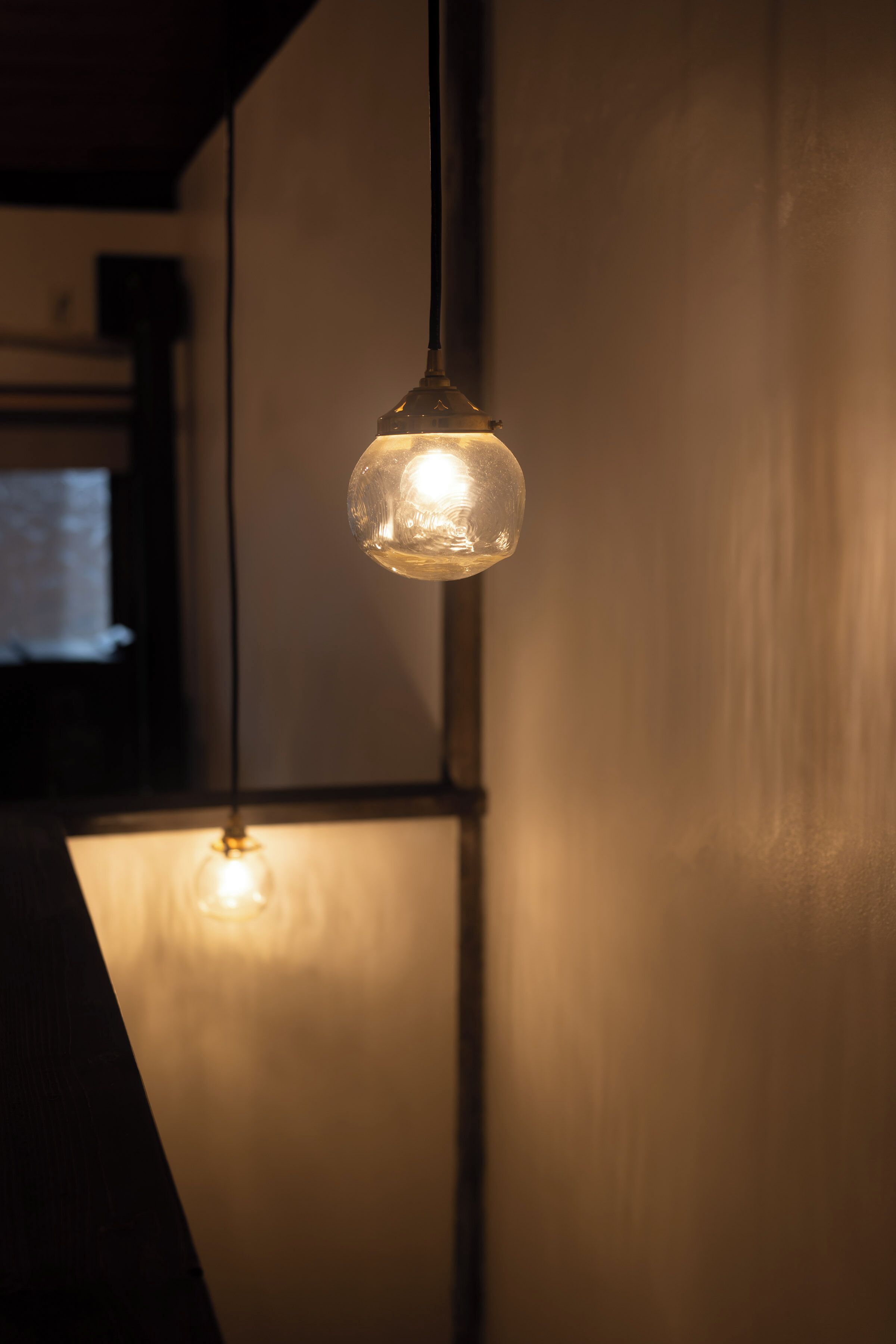 A hanging light fixture with a clear glass shade.