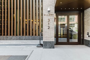 The entrance to The Gallery with a brick facade, numbered 312, and a glass door. - Blueground | Midtown South, gym, nr Times Square (New York)