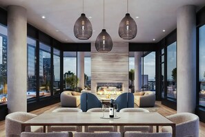 A modern dining area with a large table, comfortable seating, and a fireplace. - Blueground | Midtown South, gym, nr Times Square (New York)