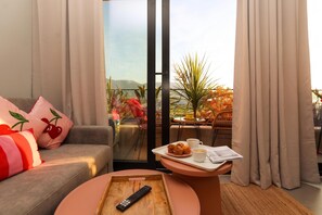 Un'accogliente zona giorno con divano, tavolino e vista sul balcone.