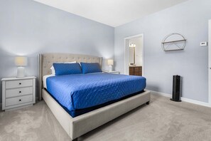 A bedroom with a bed, bedside tables, a mirror, and a wall-mounted heater. - Hadlock House - NEW! Home in Southwest Harbor (Southwest Harbor)