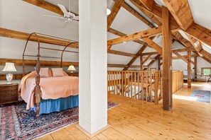 A bedroom with a four-poster bed, a ceiling fan, and a wooden floor. - The Barn on the Bagaduce - NEW! Waterfront (Sedgwick)