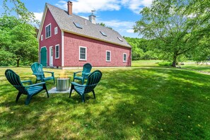 A red house with a chimney, surrounded by a well-maintained lawn and trees. - The Barn on the Bagaduce - NEW! Waterfront (Sedgwick)