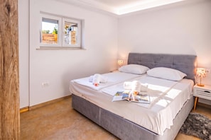 Une chambre à coucher avec un lit, une fenêtre, une table de chevet avec une lampe et un tapis.