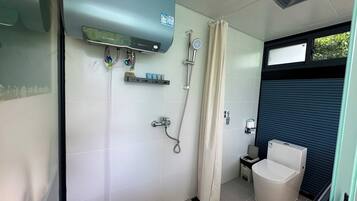 A bathroom with a shower, toilet, and a water heater.