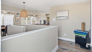 A modern kitchen with a peninsula, a dining area, and a view of the ocean.