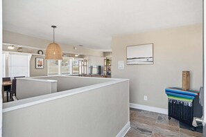 A modern kitchen with a peninsula, a dining area, and a view of the ocean.