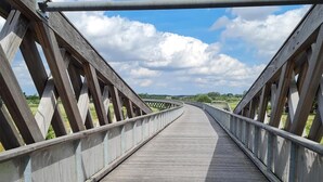 A wooden pedestrian bridge with a metal railing and a clear sky. - Beautiful home in Oude Pekela with sauna (Oude Pekela)