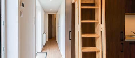 A hallway with a wooden ladder, a radiator, and a door leading to another room.