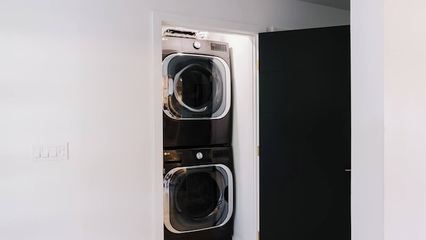 A laundry room with two stacked front-loading washers and dryers. - ᔦ-𐌊𐌉𐌍Ᏽ 𐌄𐌍-𐌔𐌵𐌉𐌕𐌄𐌔 + 𝓗Ꝋ𐌕 𐌕𐌵𐌁 (Sedona)