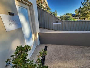 A guest parking area with a sign indicating the direction to the guest suite.