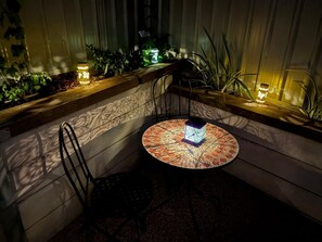 A corner seating area with a round table, a chair, and a decorative box.