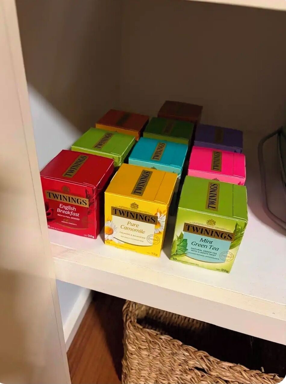 A shelf with various Twinings tea boxes.