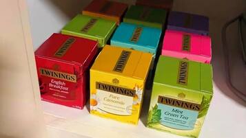 A shelf with various Twinings tea boxes.