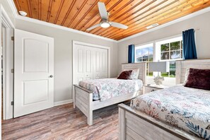 A room with two beds, a ceiling fan, and a window with curtains. - Sea La Vie | Coastal Comfort by the Beach (North Myrtle Beach)