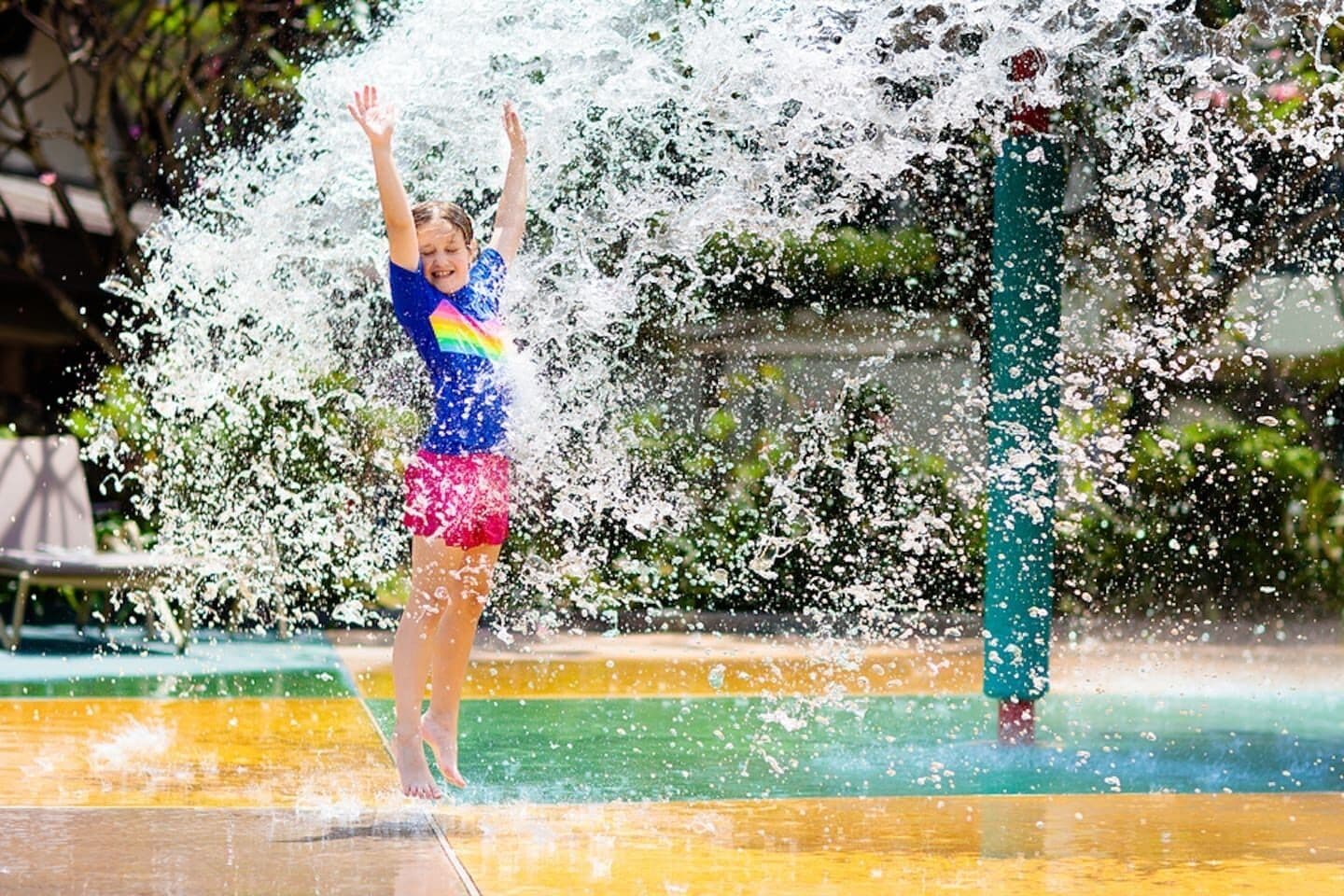 A person playing in a water feature with a colorful design.