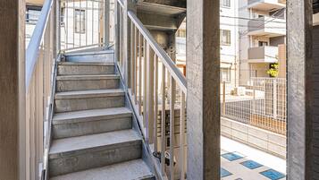 Un escalier en béton avec des rampes métalliques menant à un niveau supérieur.