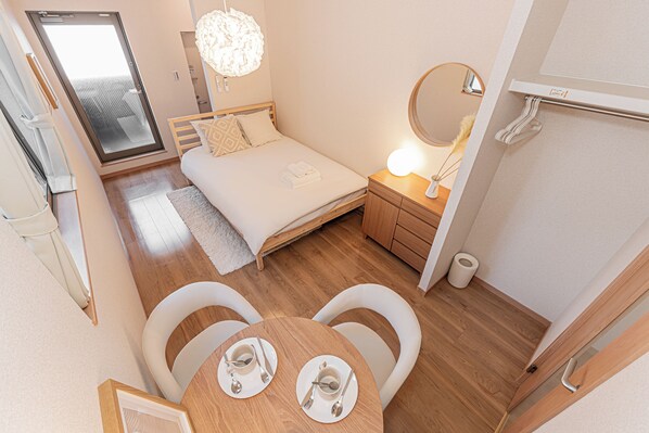 A compact bedroom with a bed, bedside table, and a mirror. - The Parknest Haneda (Tokyo)