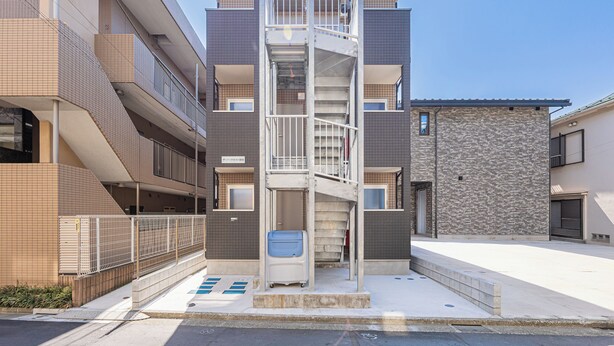 A multi-story residential building with a central staircase, balconies, and a gated entrance. - The Parknest Haneda (Tokyo)