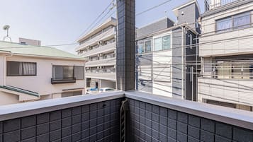 Een woongebouw met meerdere verdiepingen, balkons en een zichtbaar straatbeeld.