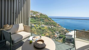 Een balkon met een bank, een hoed, een schaal en een boek.
