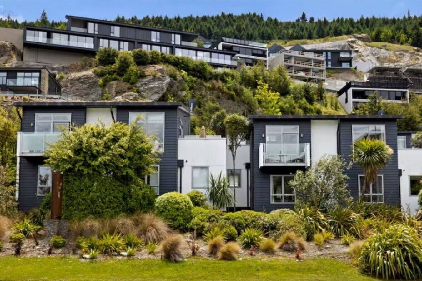 A modern residential complex with multiple two-story houses, each featuring balconies and large windows.