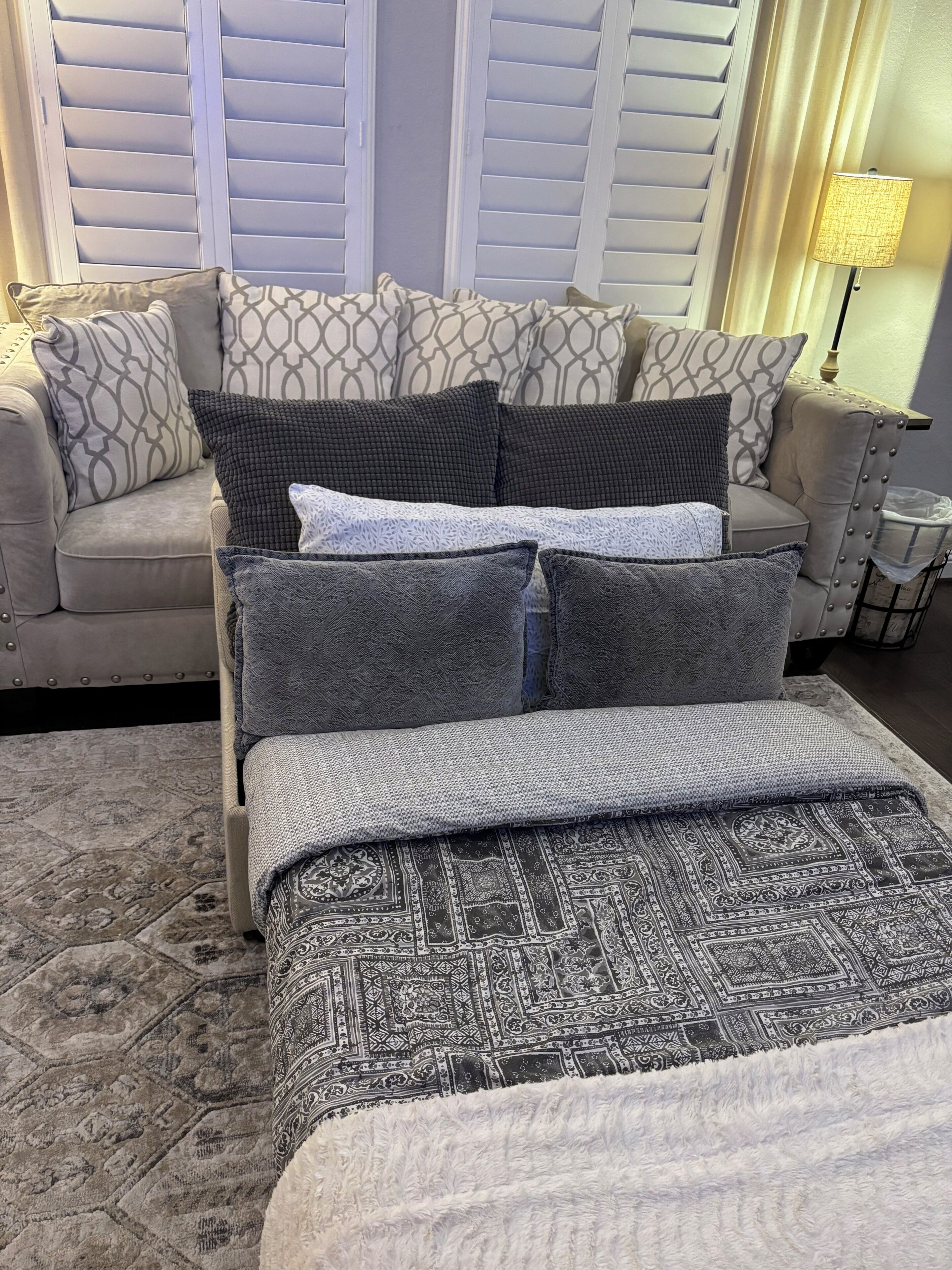 A bedroom with a bed, a sofa, and a nightstand.