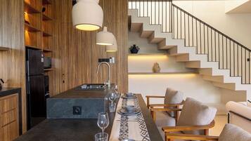 Una cocina moderna con una isla central, muebles de madera e iluminación colgante.