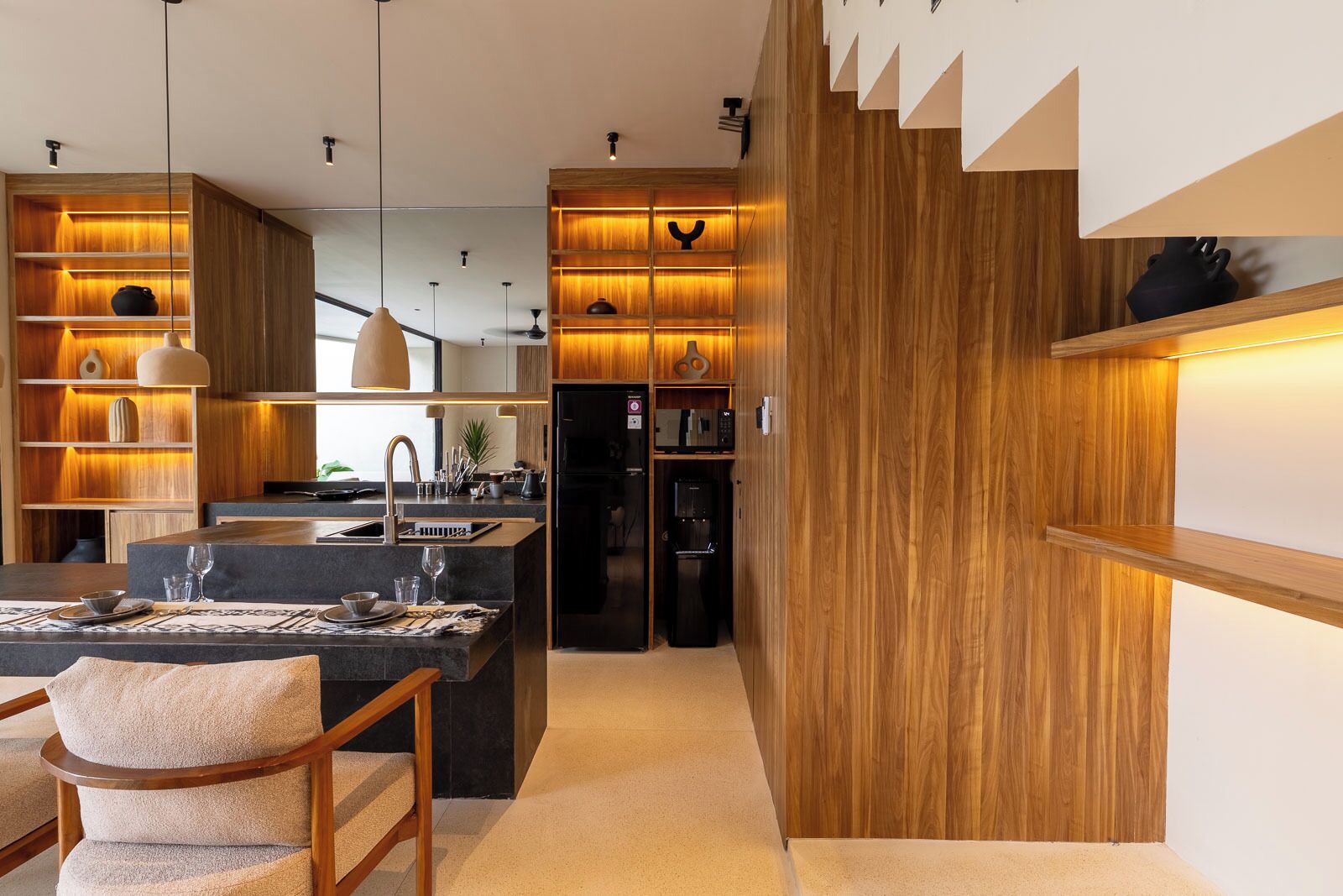 A modern kitchen with wooden cabinetry, a central island, and pendant lighting.
