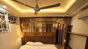 A bedroom with a bed, a ceiling fan, a window with bars, and an air conditioning unit. - Bungalow with a pool, just a few minutes from the beaches (Las Terrenas)