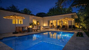 A swimming pool with a lounge area, outdoor seating, and string lights. - Designer Pool Home • Near Las Olas • Sleeps 10 (Fort Lauderdale)