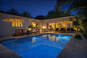 A swimming pool with a lounge area, outdoor seating, and string lights. - Designer Pool Home • Near Las Olas • Sleeps 10 (Fort Lauderdale)