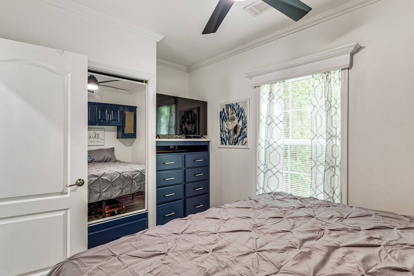 Une chambre à coucher comprenant un lit, une armoire et un bureau avec des tiroirs.