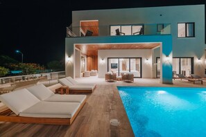 Ein modernes, zweistöckiges Gebäude mit Schwimmbad, Außenbereich und Balkon.