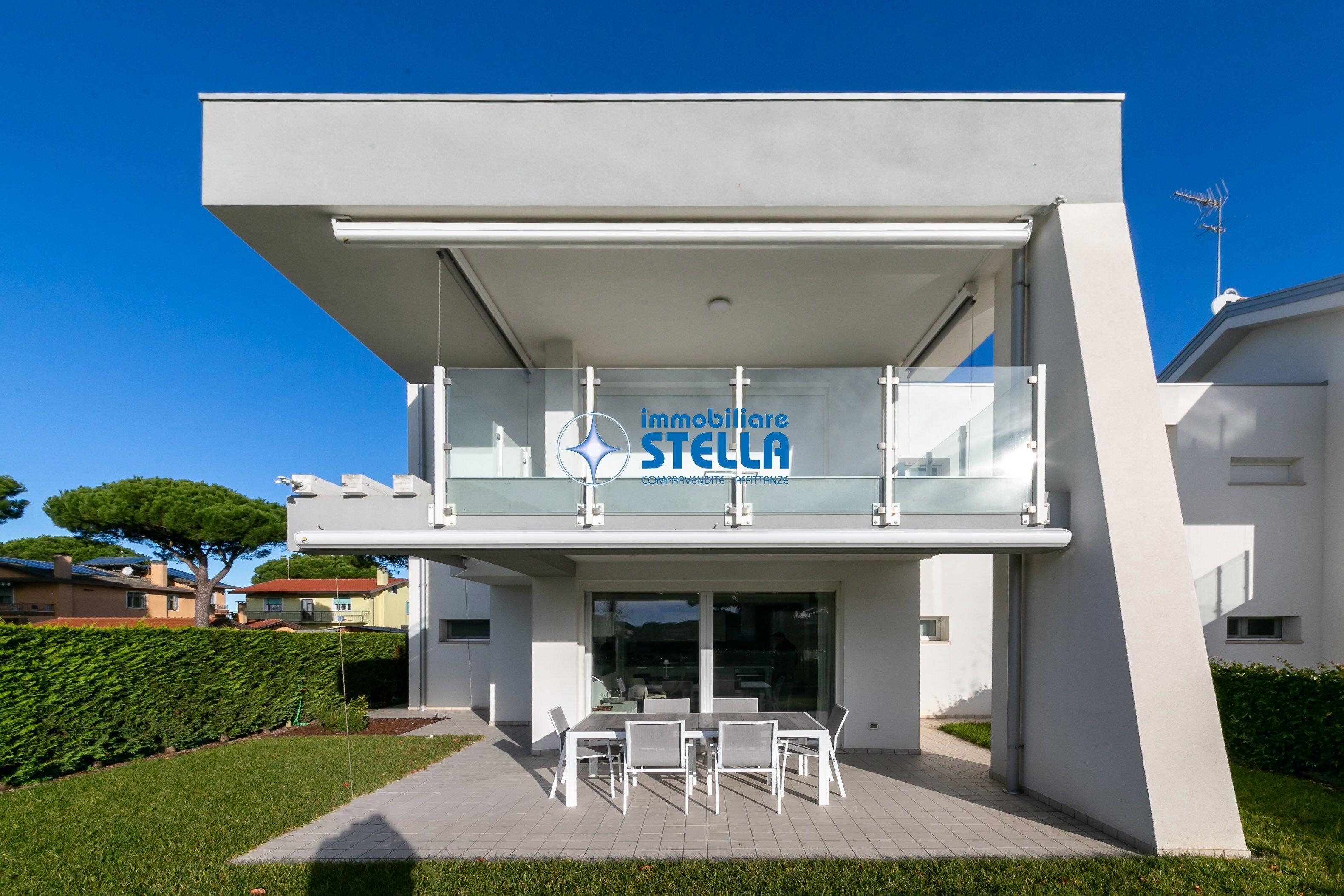 Ein modernes Gebäude mit Glasfassade, auf der das Wort 'immobiliare STELLA' gut sichtbar angebracht ist.